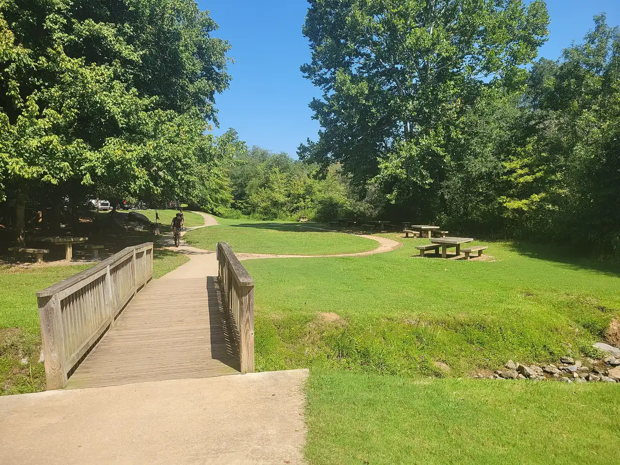 A footbridge and picnic tables in the picnic area at Olde Rope Mill Park in Woodstock