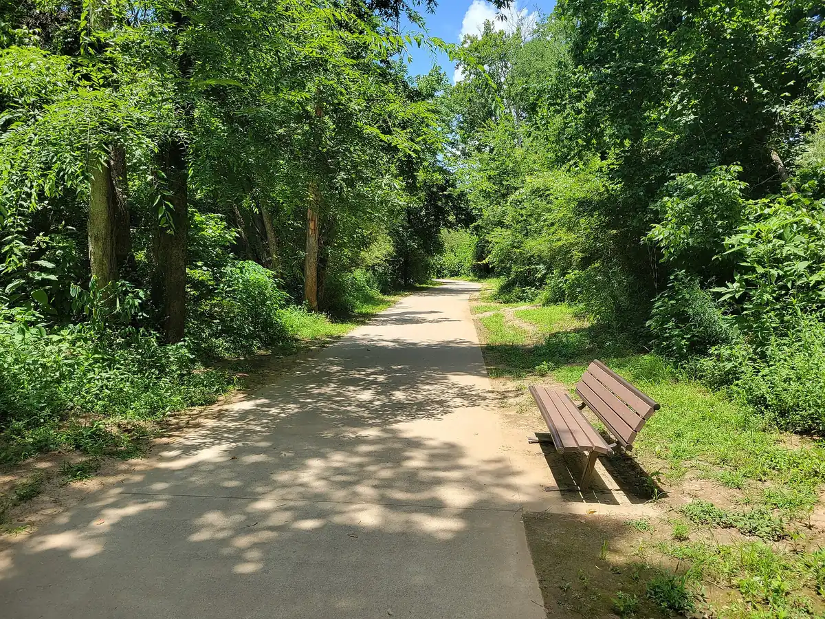A bench on Towne Lake Pass, the city trail that runs along Towne Lake Hills South Drive and under I-575
